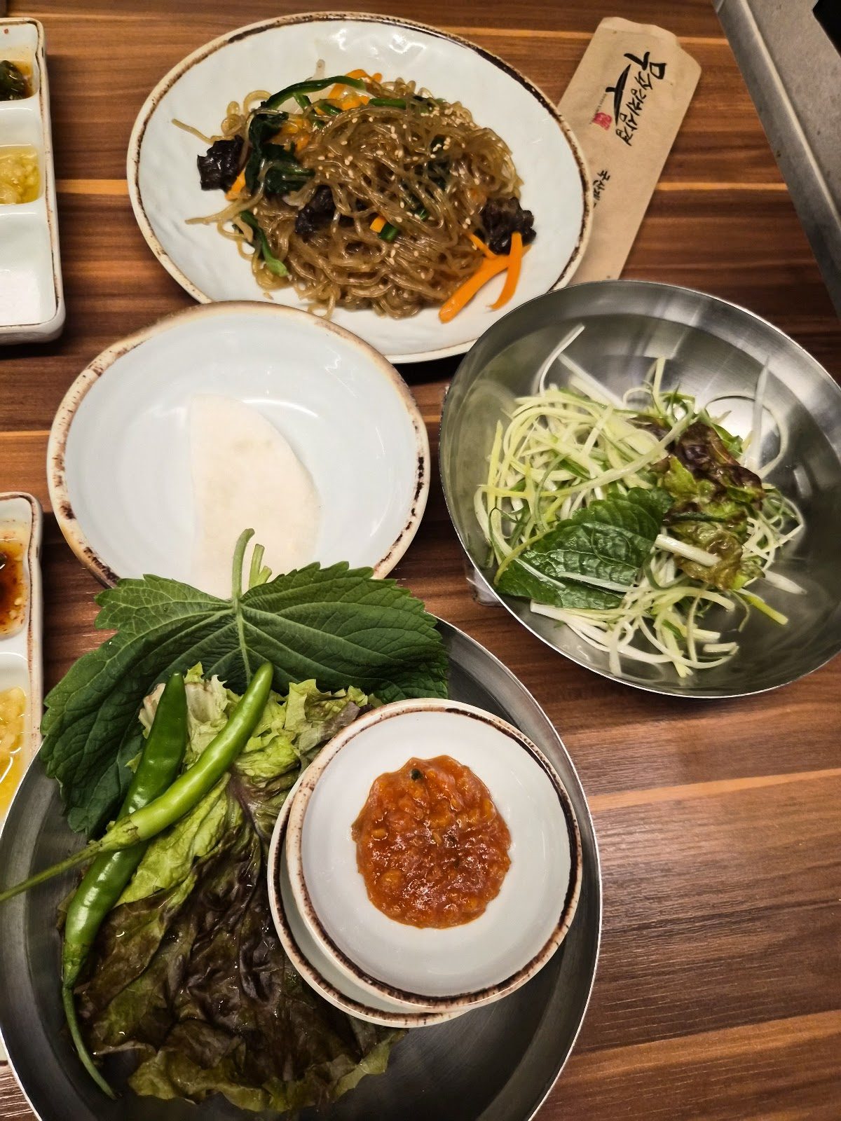 잡채 한 접시와 파채, 상추·깻잎·풋고추 쌈채소, 쌈장